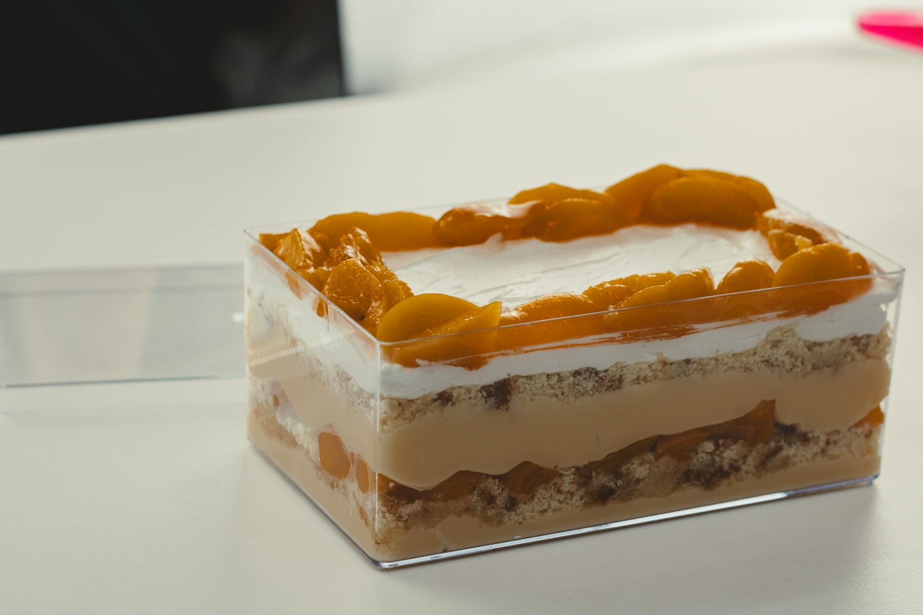 لایه‌چینی بیسکویت و مایه شکلاتی در کیک یخچالی