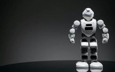 Close-up of a white toy robot on a reflective surface with dark background.