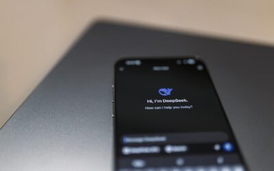 Close-up of a smartphone with AI assistant interface on screen over a laptop.