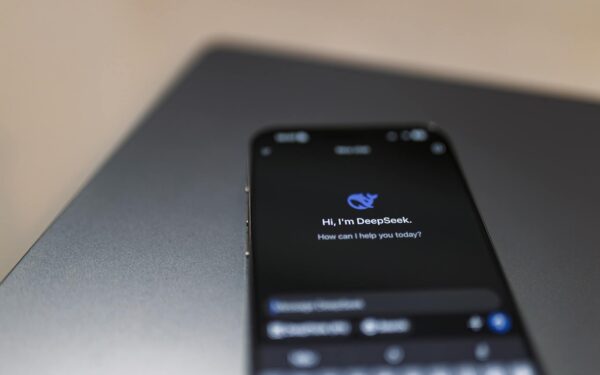 Close-up of a smartphone with AI assistant interface on screen over a laptop.