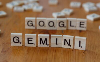 Scrabble tiles spelling out Google and Gemini on a wooden table, focusing on AI concepts.