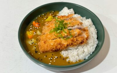 Tasty Japanese chicken katsu curry on rice garnished with sesame seeds.