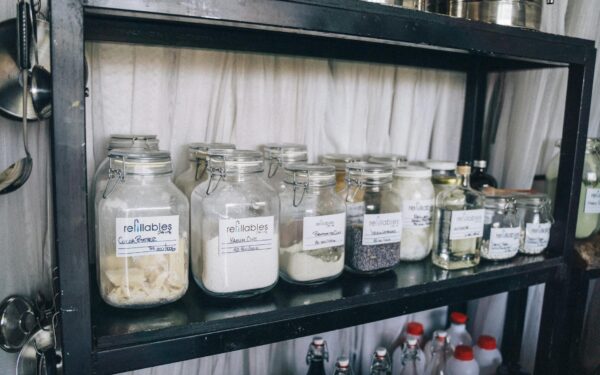 Organized glass jars on a pantry shelf for eco-friendly food storage and sustainability.