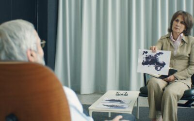 A therapist and patient in a psychotherapy session, discussing inkblot test results.