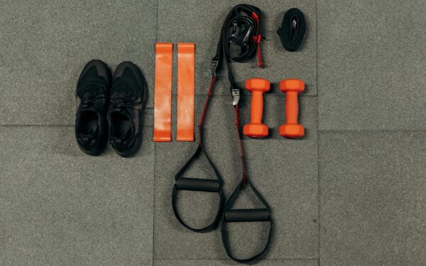 Flat lay of fitness gear including dumbbells, sneakers, and resistance bands for a home workout.