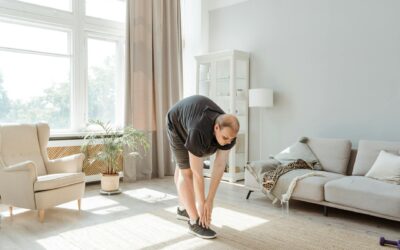 Adult exercising and stretching in a bright living room with natural light.