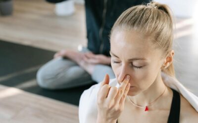 Woman meditating indoors practicing yoga breathing techniques with focused concentration.