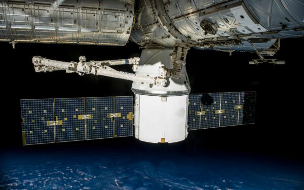 A satellite with solar panels orbiting Earth, capturing the vast universe.