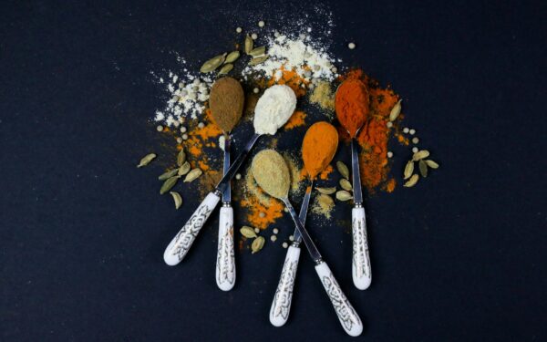 A vibrant assortment of spices on spoons, perfect for culinary themes.