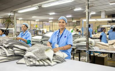 Female textile workers sorting rugs in a well-lit factory setting.
