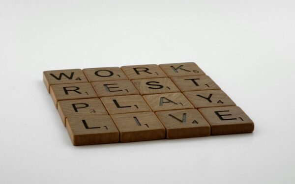 Scrabble tiles spelling work, rest, play, live emphasize life balance and priorities.