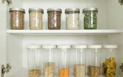 Neatly arranged pantry showcasing grains in glass jars and dry goods in plastic containers.