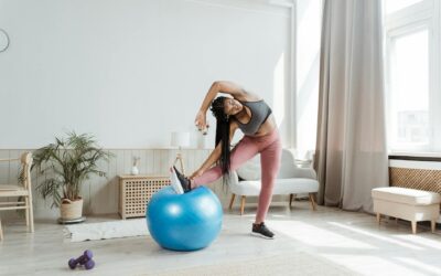 African American woman engages in fitness routine with exercise ball indoors.