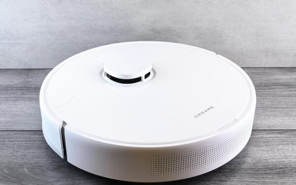 Sleek white robot vacuum cleaner on a wooden floor, perfect for smart home setups.