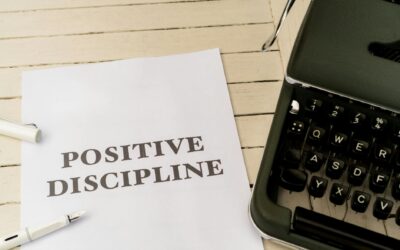 Vintage typewriter next to a paper with 'Positive Discipline' text, symbolizing communication and education.