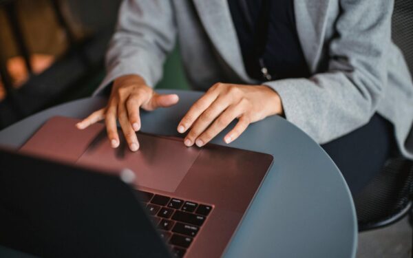 Focused woman working remotely on her laptop at a stylish outdoor café.