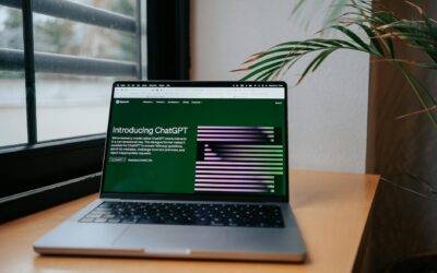 A laptop displaying ChatGPT on a desk by a window, featuring a modern home office setup.