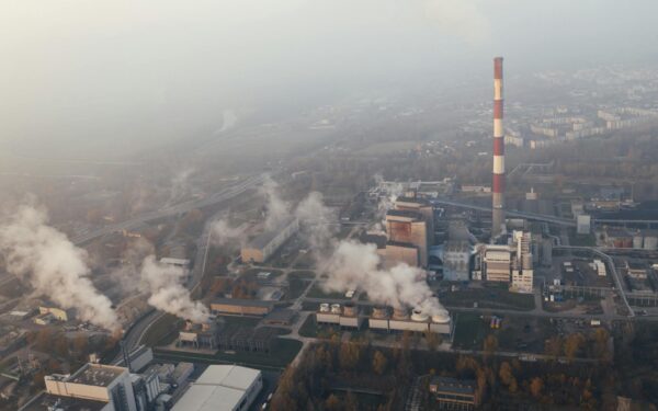 Aerial shot of an industrial plant in Poznań emitting smoke and pollution.