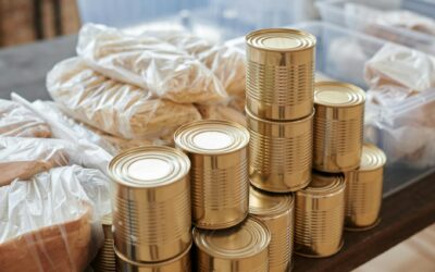 A stack of canned goods and packaged foods on a table, perfect for donation drives.