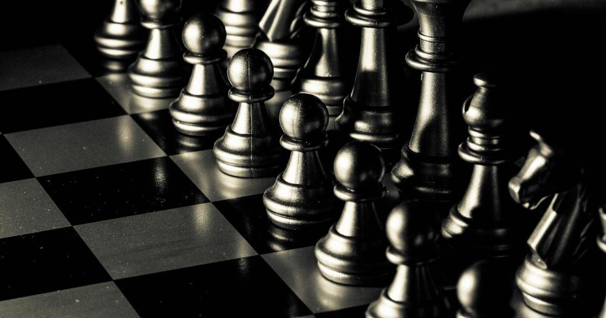 Close-up of a chessboard with pieces set for a strategic game, symbolizing intellect and plaing.