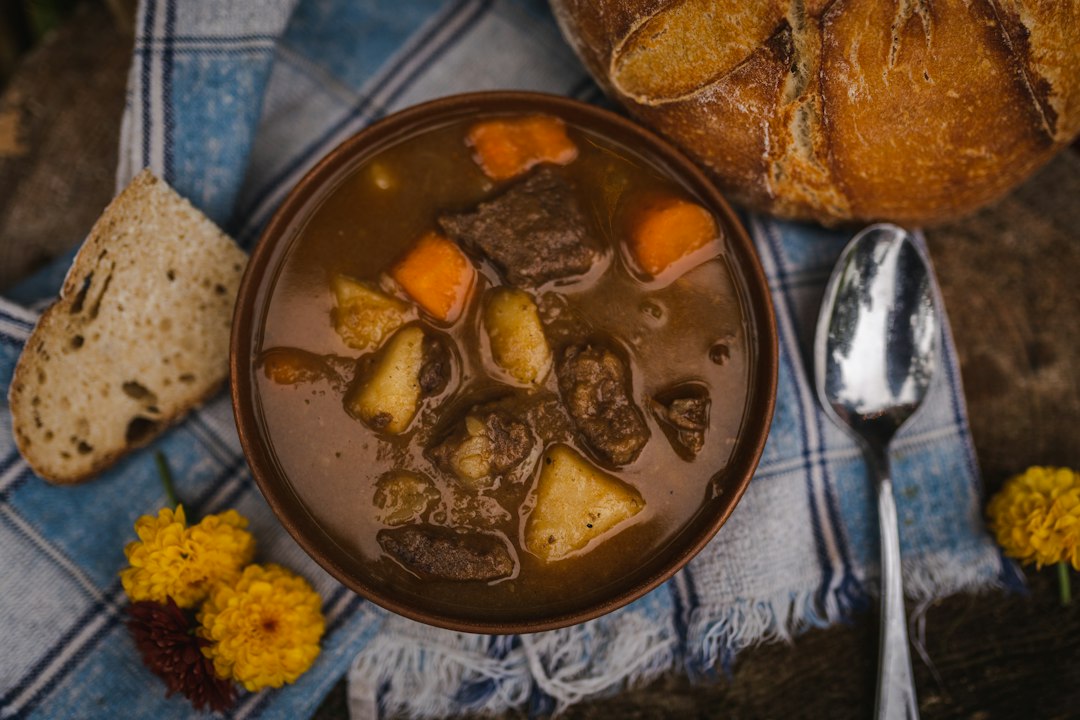 قل زدن آرام خورش به آلو مجلسی در قابلمه مسی و غلیظ شدن سس