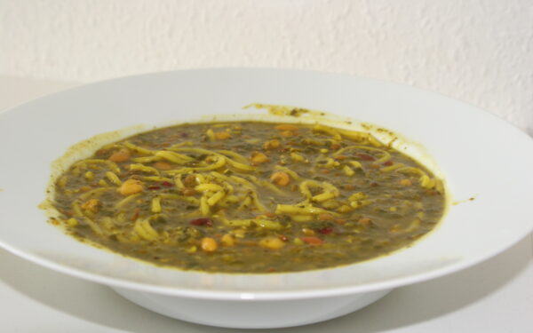 کاسه آش رشته مجلسی با تزیین کشک، نعناع داغ و پیاز داغ چیپسی