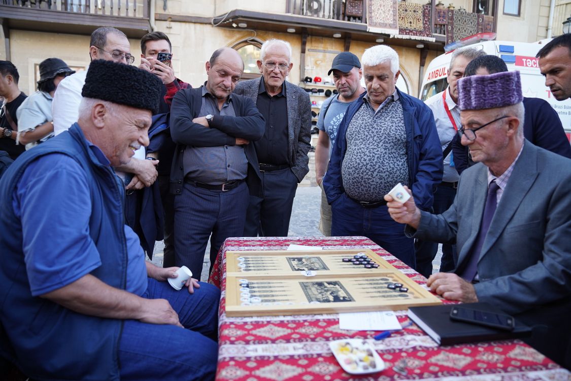 جمع صمیمی بازیکنان و تماشاگران در حال تجربه رقابت پرهیجان تخته نرد