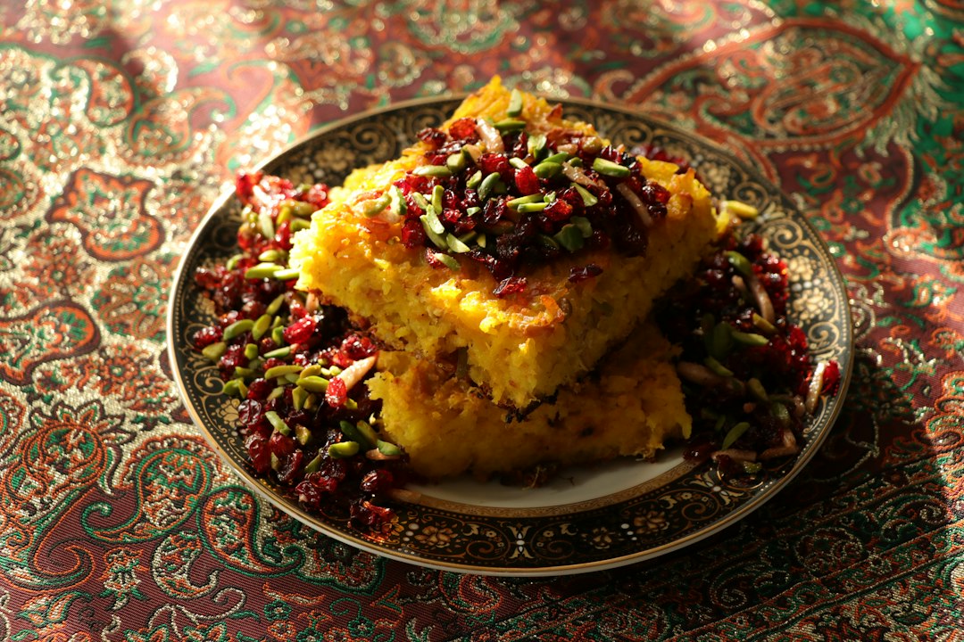 خورشت قورمه سبزی غلیظ و جاافتاده ایرانی سرو شده در کاسه سنتی کنار چلو زعفرانی